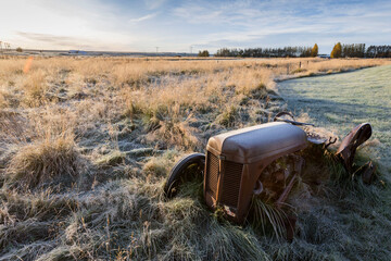 stary zardzewiały traktor w polu o zachodzie słońca © Aleksandra