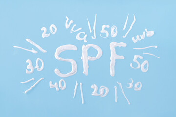 Choosing level degree of sun protection for adults or children. Plastic bottle of sunscreen lotion with cream text numbers of SPF, UVB, UVA filters, on bright background, top view flatlay copy space