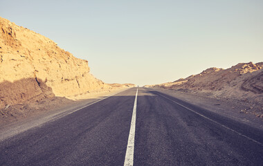 Desert road, front focus on asphalt, travel concept, color toning applied, Egypt.