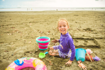 Portrait of girl of 4 years on beach of Costa Rica play on sand beach