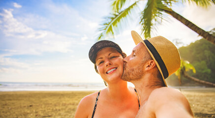 nice couple taking selfie portrait on beach on sunset