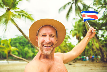 man holding costa rica flag on Costa Rica beach