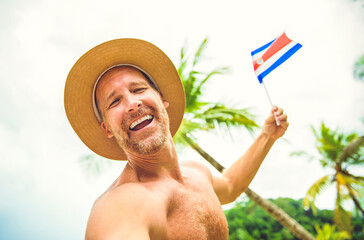 man holding costa rica flag on Costa Rica beach