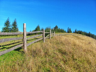 Rustic Wooden Fence on Hillside Meadow