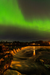 Aurora borealis, The Northern lights over Venta waterfall. Kuldiga, Latvia.