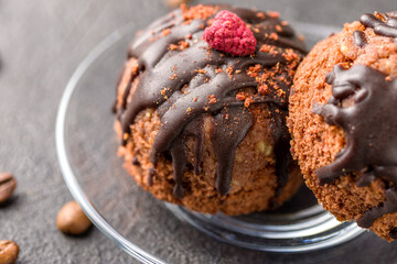Round chocolate cakes. Decorated with candied raspberries. Dark background