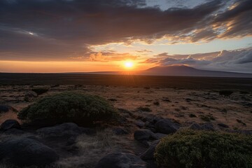 Obraz premium Serene sunset casts warm hues over a vast volcanic field with silhouetted mountains in the distance