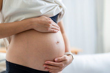 Pregnant woman hold her belly close up