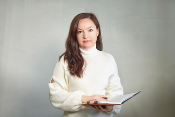 Confident middle aged Business woman in White Turtleneck with Notebook. A professional mature woman...