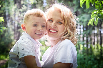 Fototapeta premium Tender Moment Between Mother and Child in a Sunlit Forest