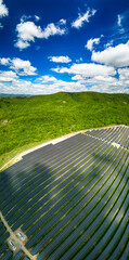 Solar panel produces green, environmentaly friendly energy from the setting sun. Aerial view from drone. Landscape picture of a solar plant that is located inside a valley
