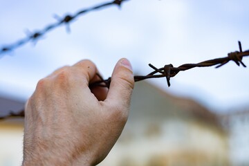 Hand and barbed wire. Violation of the law on the departure of citizens from Ukraine	