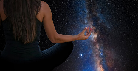Woman meditating with the universe in the background