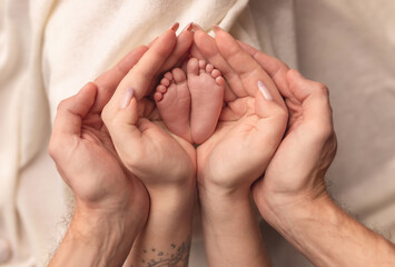 Children's feet in the arms of their parents. On a white background.