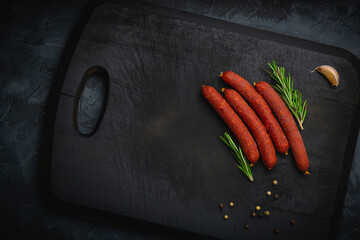 Sausages Kabanos. On a black cutting board background. Top view. Free copy space.