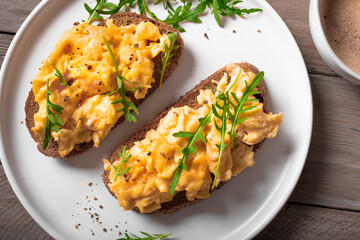 Scrambled eggs sandwiches with arugula microgreens