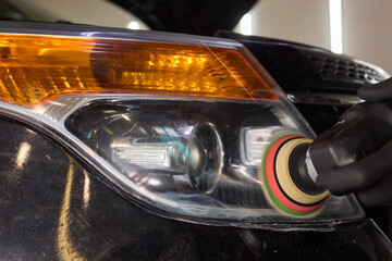 Person using a machine to polish automotive lighting on a car headlight