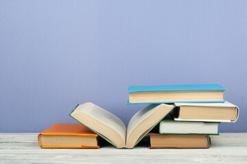 Open book, hardback colorful books on wooden table. Back to school. Copy space for text. Education business concept.
