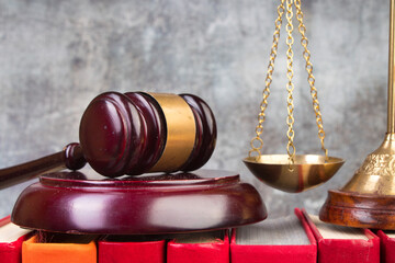 Law concept - Open law book, Judge's gavel, scales on table in a courtroom or law enforcement...