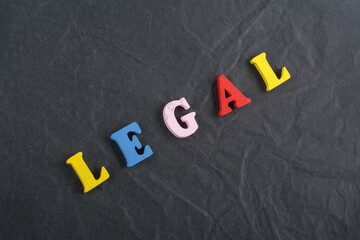 LEGAL word on black board background composed from colorful abc alphabet block wooden letters, copy...