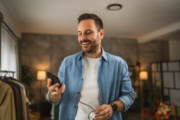 Adult caucasian man hold and use mobile phone at home happy relax