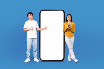 Chinese man and a woman are standing next to a large phone, presumably engaged in a conversation,...