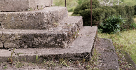Old cement stairs are destroyed under the influence of wet weather and time, the stairs need repair
