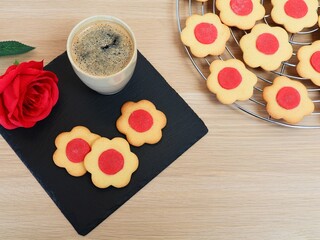 Homemade  cookies in flower shape, cup of coffee and a rose. Concept for mother's day, valentine, love. Copy space.