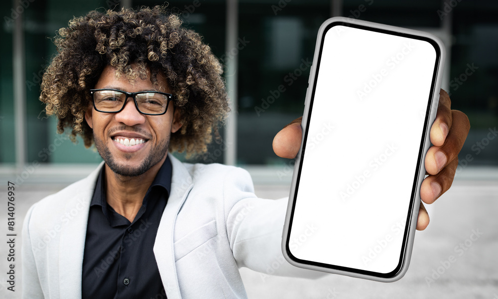 Poster Black man standing and holding a smartphone in front of him, displaying a blank white screen. The mans hand is clearly visible as he holds the device upright.
