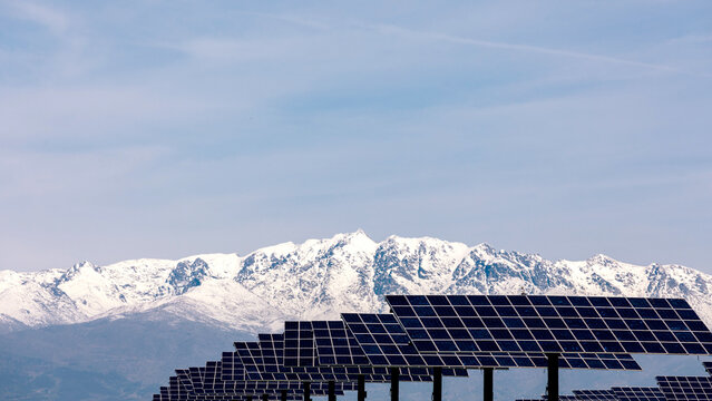 Solar panels with snowy mountains in the background