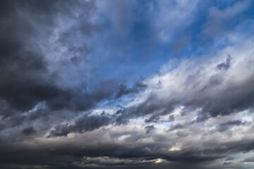 Storm cloudy epic dramatic sky with dark rain grey cumulus cloud and blue sky background texture, thunderstorm, heaven