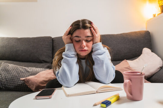 Stressed young girl studying at home