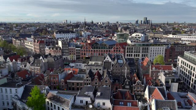 Historical Center of Amsterdam, Netherlands. Aerial Drone Shot of Traditional Dutch houses on narrow street and channel.