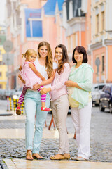 Fototapeta premium Outdoor family portrait - three women with little girl.