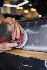 Person using a machine to polish automotive lighting on a car headlight