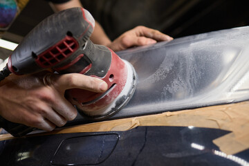 Person using a machine to polish automotive lighting on a car headlight