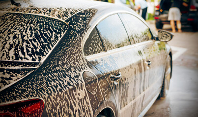 White foam is applied to the car body at the car wash