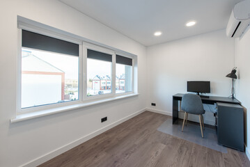 Comfortable workplace with computer near white wall in stylish minimalism room interior. Home office design