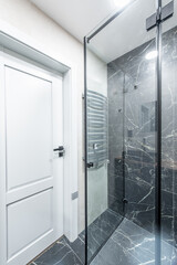 Interior of Luxury chromed shower in modern marble bathroom. Spacious bathroom in gray tones with heated floors. Furniture, sink, shower. Marble