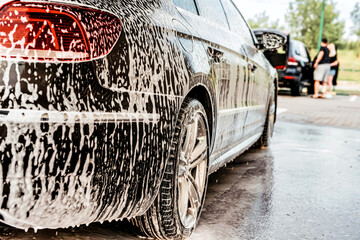 White foam is applied to the car body at the car wash