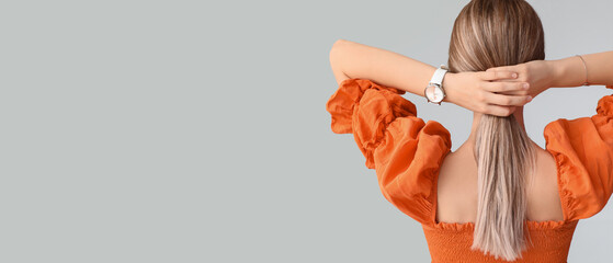 Woman with stylish wrist watch on light background