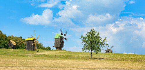 Fototapeta premium Old wooden mills against background blue sky.