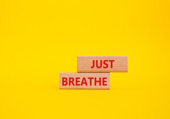 Just Breathe symbol. Wooden blocks with words Just Breathe. Beautiful yellow background. Business and Just Breathe concept. Copy space.