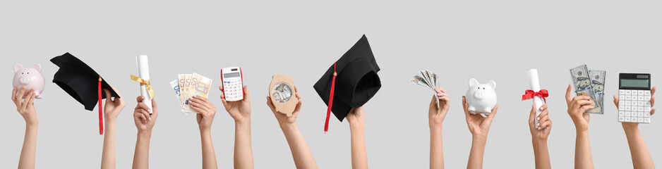 Female hands holding piggy banks, graduation cap, diploma and money on grey background. Student...