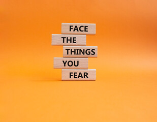 Face the things you fear symbol. Wooden blocks with words Face the things you fear. Beautiful orange background. Business and Face the things you fear concept. Copy space.