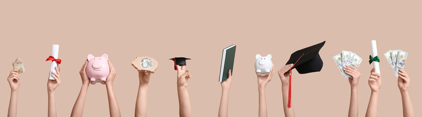 Female hands holding piggy banks, graduation cap, diploma and money on beige background. Student...