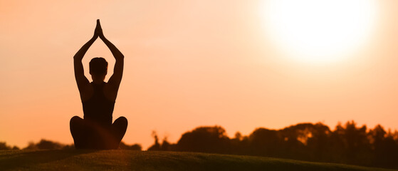 Beautiful young woman practicing yoga outdoors in the morning