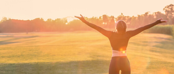 Athletic young woman enjoying nature at sunrise