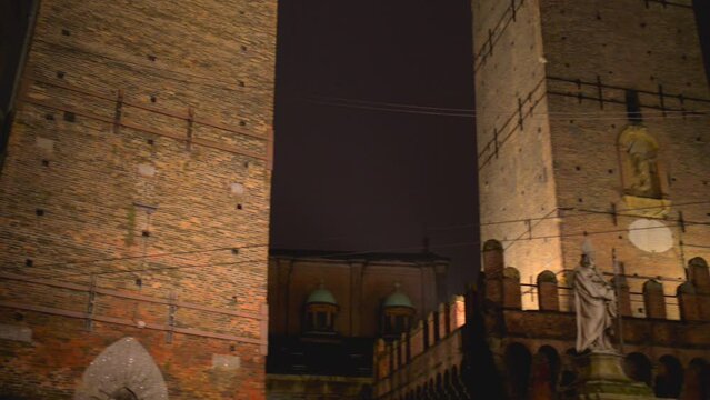 Two Towers are symbol of Bologna, Italy, and most prominent of Towers of Bologna. Taller one is called Asinelli while smaller but more leaning tower is called Garisenda. Statue of Saint Petronius.