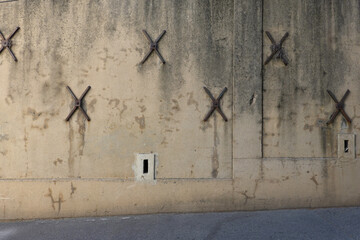 Croix de chainage et tirais de chainage sur un mur extérieur